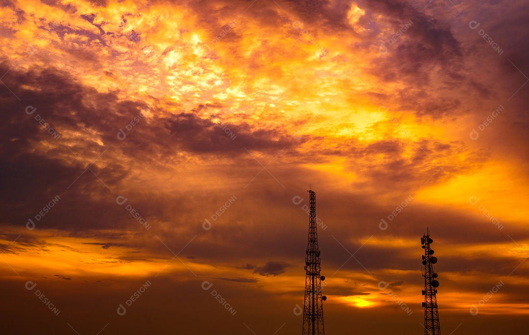 Duas torres de telecomunicações no dramático céu laranja-escuro