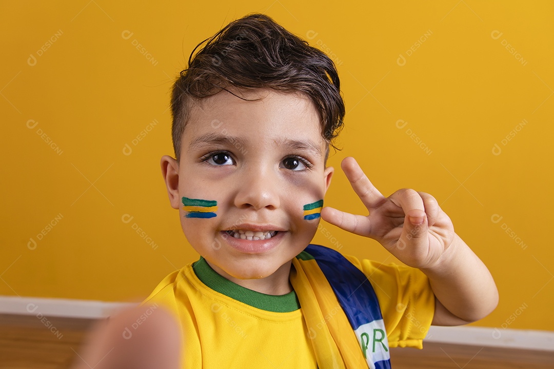 Menino jovem criança brasileiro torcedor do brasil sobre fundo amarelo