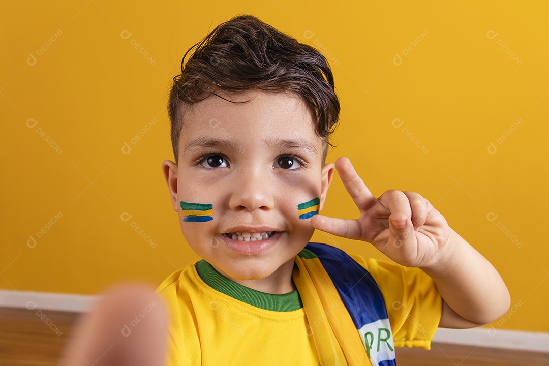 Menino jovem criança brasileiro torcedor do brasil sobre fundo amarelo