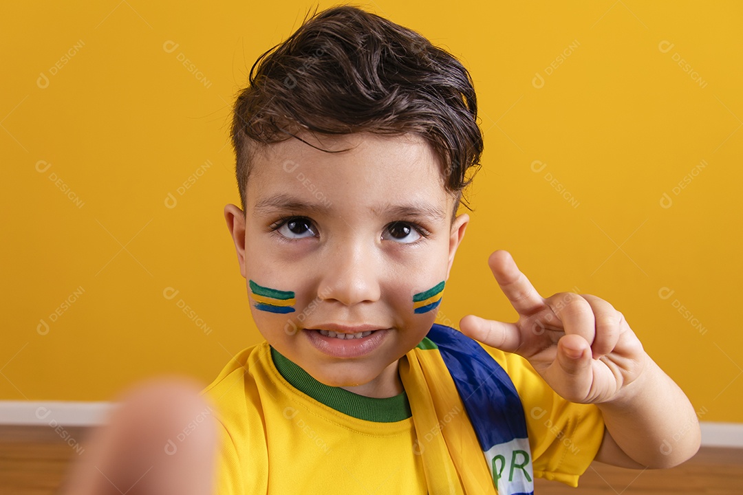 Menino jovem criança brasileiro torcedor do brasil sobre fundo amarelo