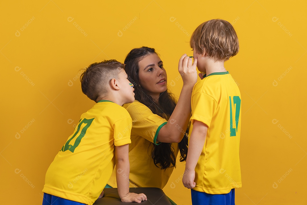 Mãe pintando seus filhos para copa do mundo