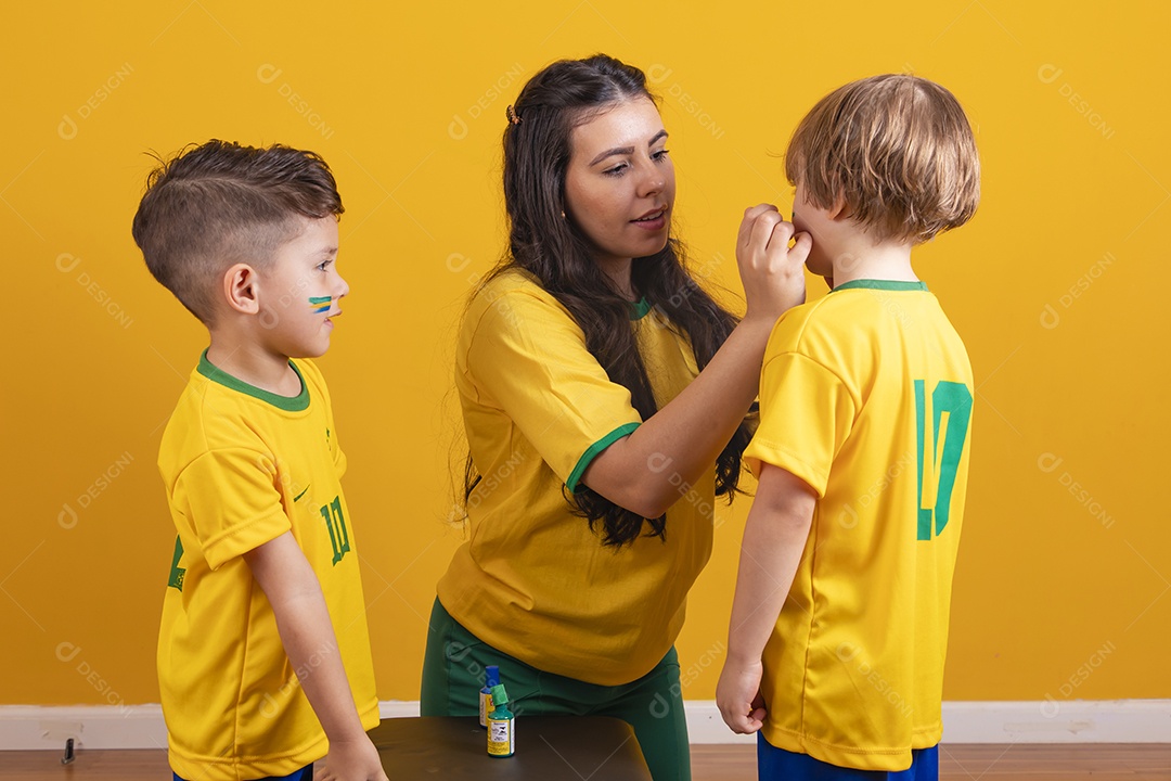 Mãe pintando seus filhos para copa do mundo