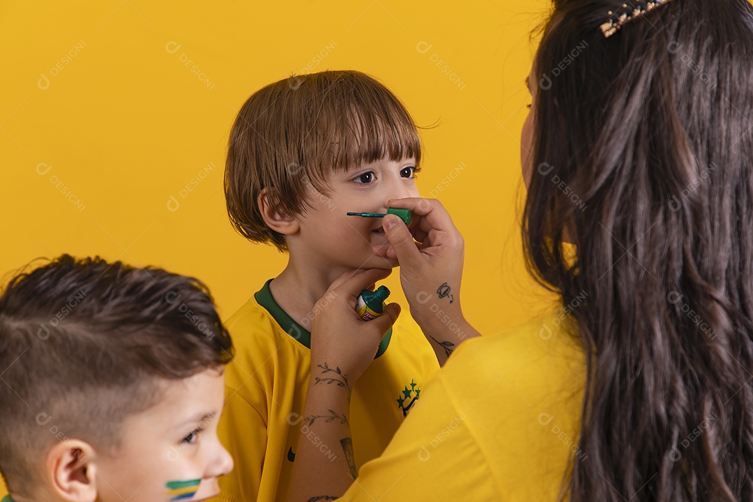Mãe pintando seus filhos para copa do mundo