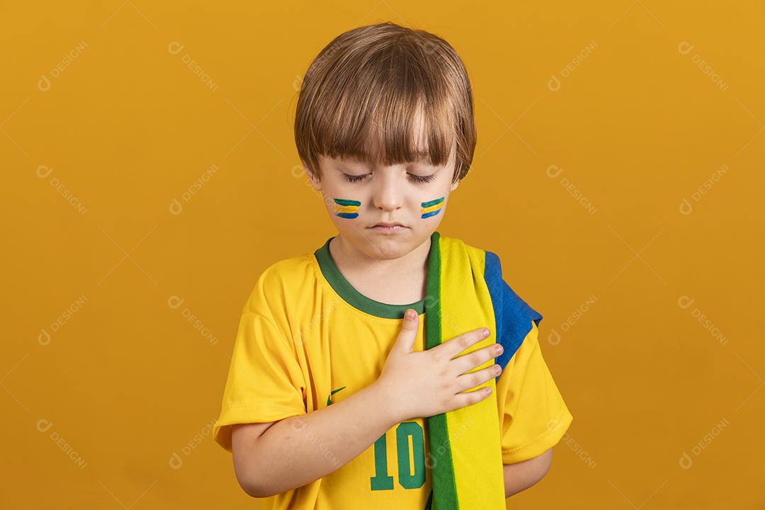 Menino jovem criança brasileiro torcedor do brasil sobre fundo amarelo