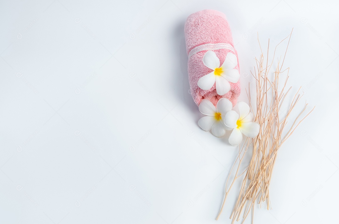 Toalha de spa rosa enrolada e flores Frangipani com ramo em branco