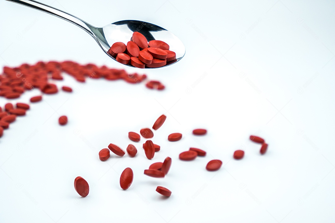 Comprimidos de ferro em colher isolados no fundo branco