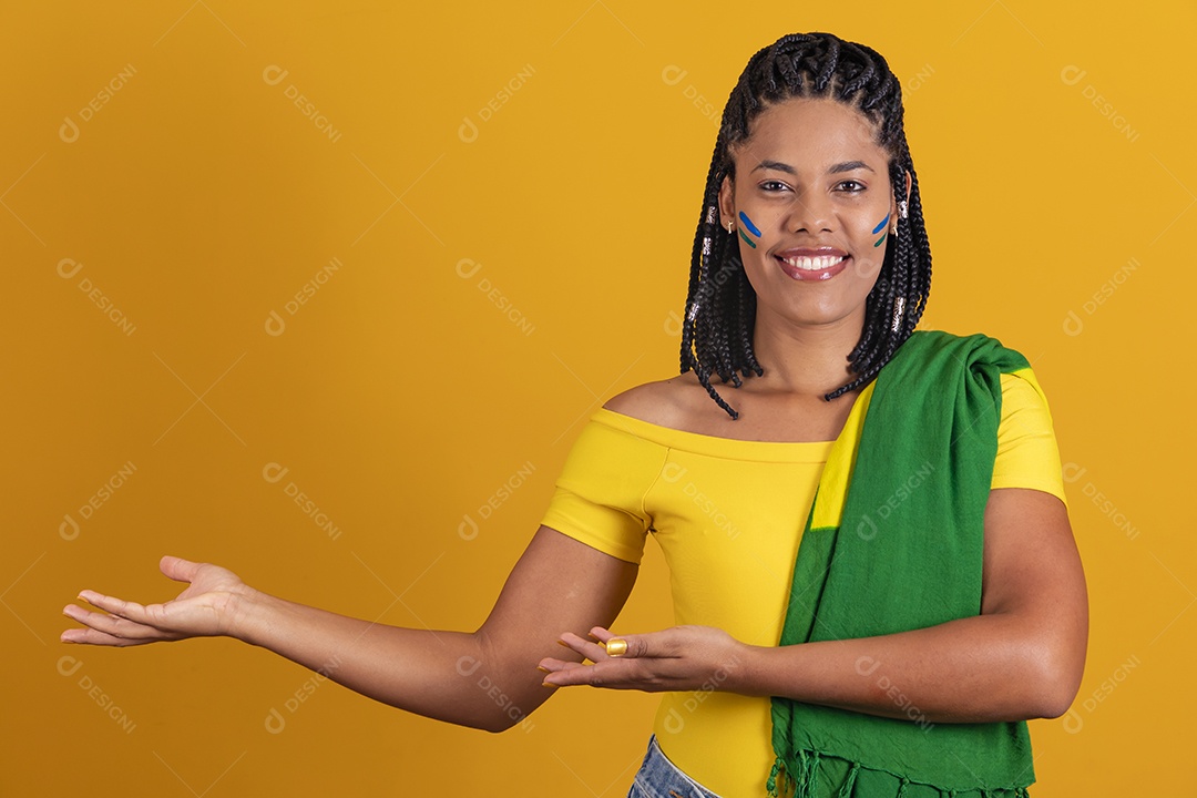 Linda mulher jovem brasileira apontando para lado fundo isolado amarelo