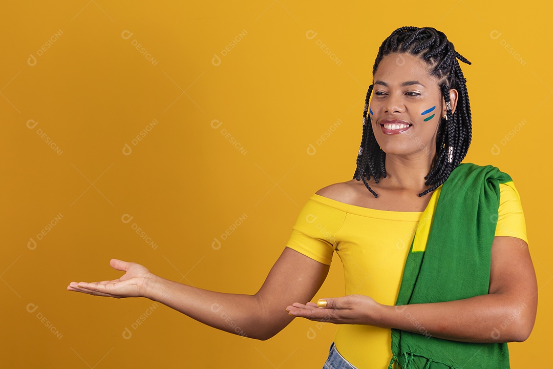 Linda mulher jovem brasileira apontando para lado fundo isolado amarelo