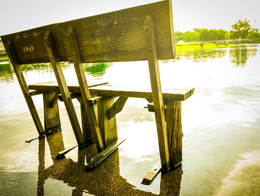 Banco de madeira velho Instalado no chão de cimento depois da chuva, inundou o chão.