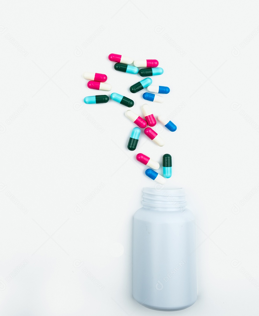 Derramando comprimidos de cápsula de antibióticos em frasco de plástico isolado no fundo branco com espaço de cópia.