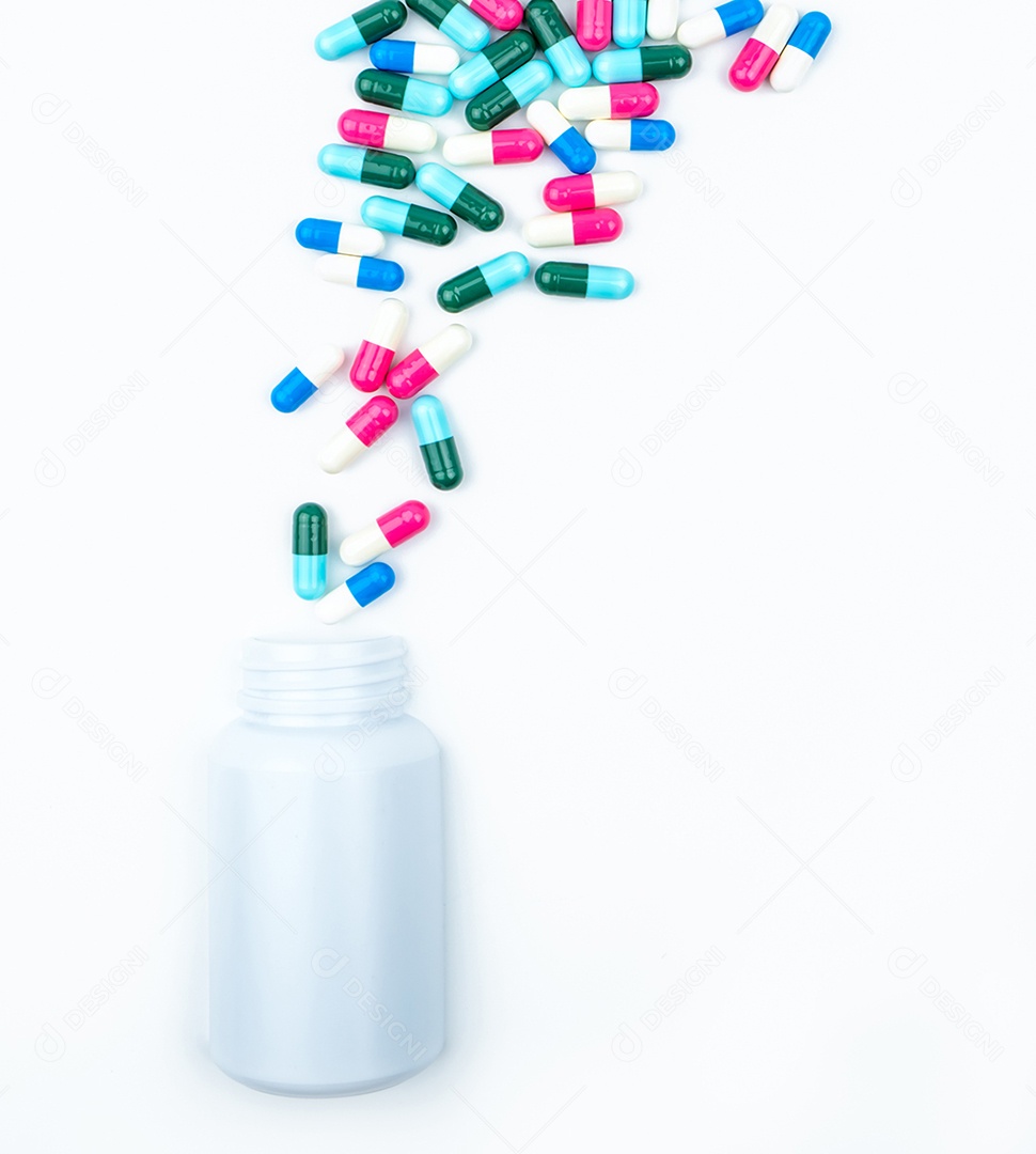 Derramando comprimidos de cápsula de antibióticos em frasco de plástico isolado no fundo branco com espaço de cópia.