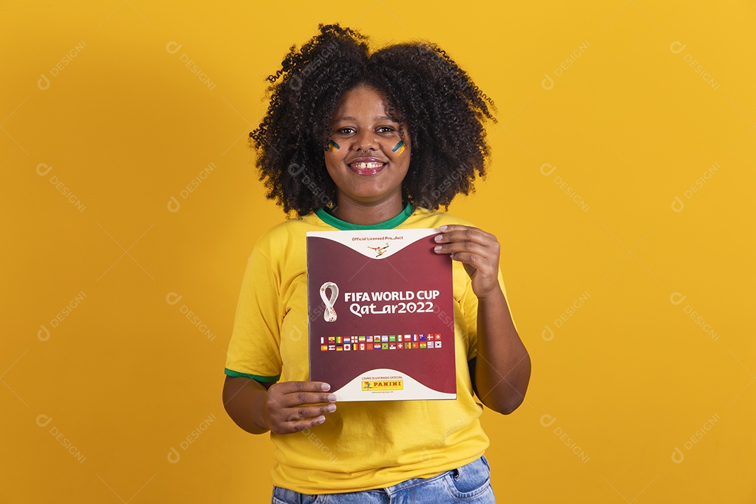 Linda mulher jovem brasileira segurando álbum da copa do mundo futebol