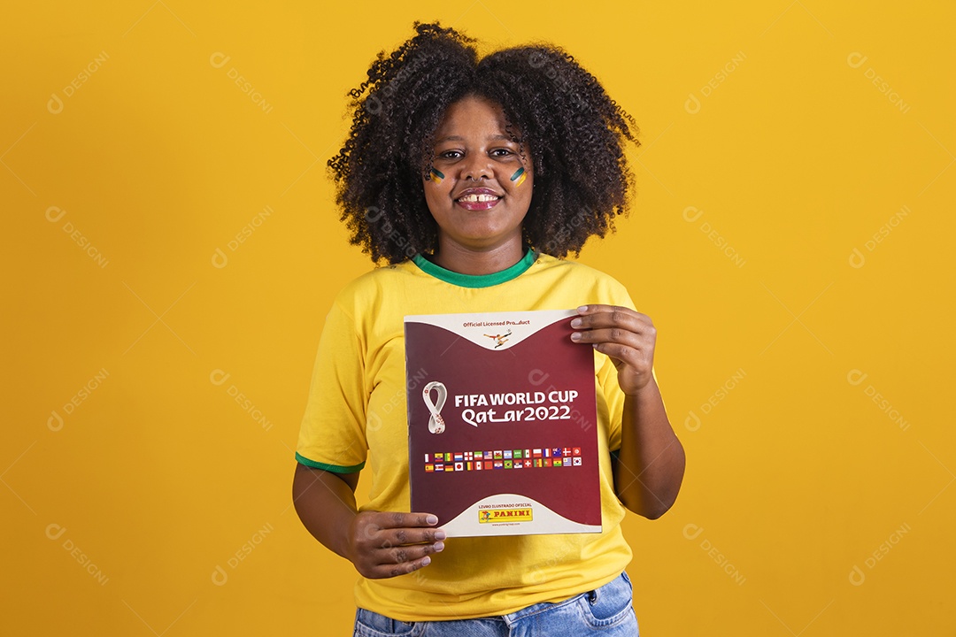 Linda mulher jovem brasileira segurando álbum da copa do mundo futebol