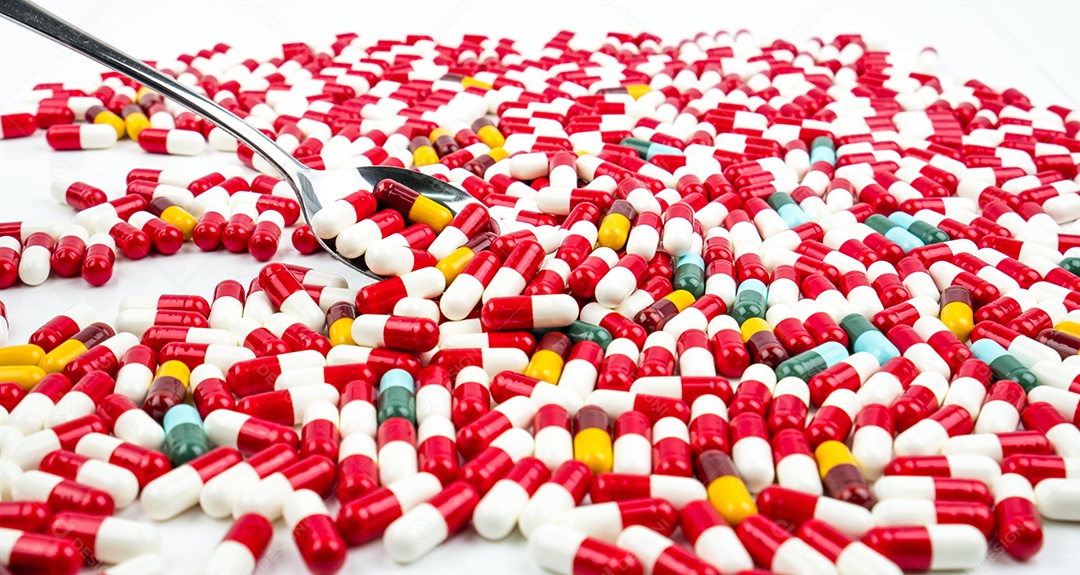 Colorido de comprimidos de cápsulas de antibióticos isolados no fundo branco.