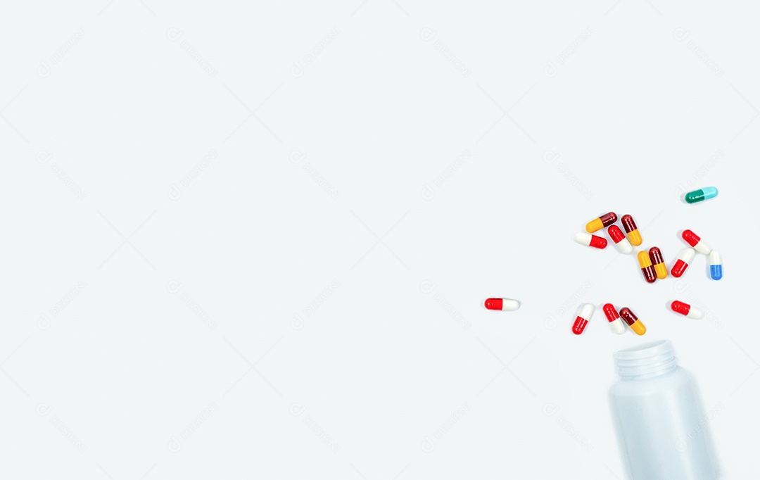 Cápsulas antibióticas coloridas e frasco plástico de drogas isolado