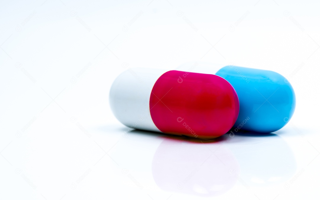 Dois comprimidos cápsula isolados no fundo branco.