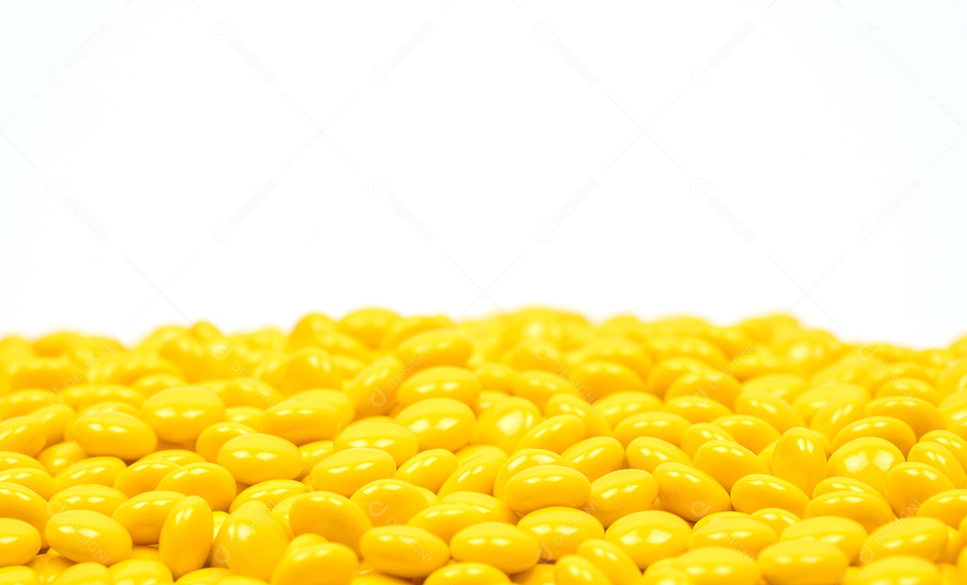 Comprimidos revestidos de açúcar amarelo em fundo branco com cópia