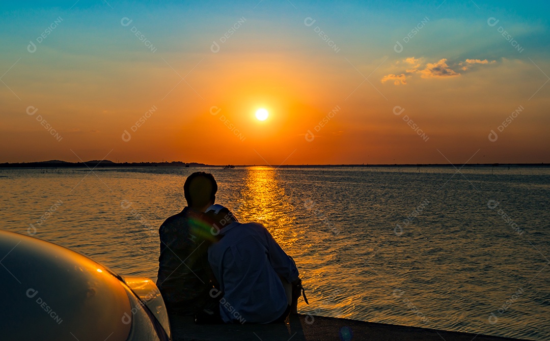 Silhueta de felicidade casal sentado e relaxando na praia
