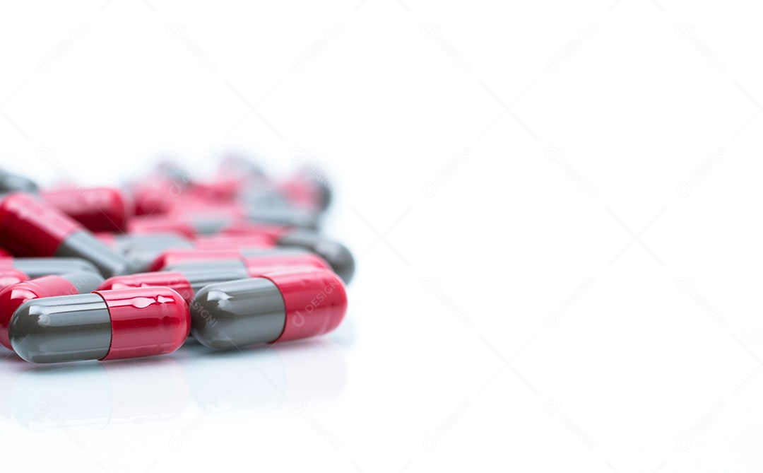 Foco seletivo de pílulas de cápsula vermelho-cinza em fundo branco