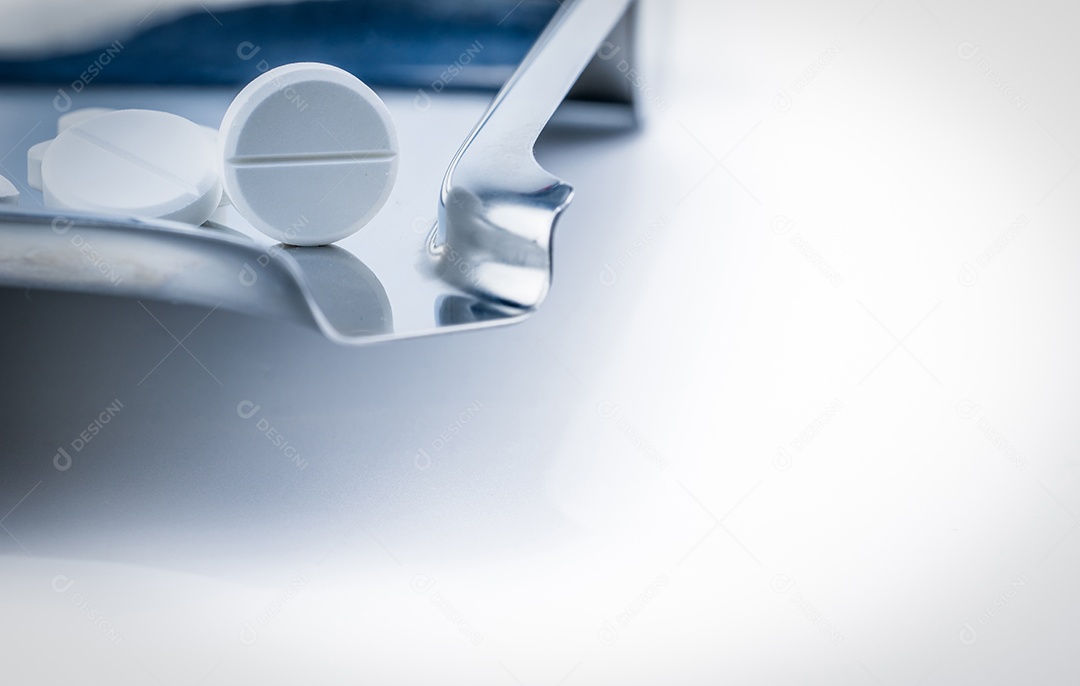 Comprimido comprimido branco na bandeja de drogas de aço inoxidável