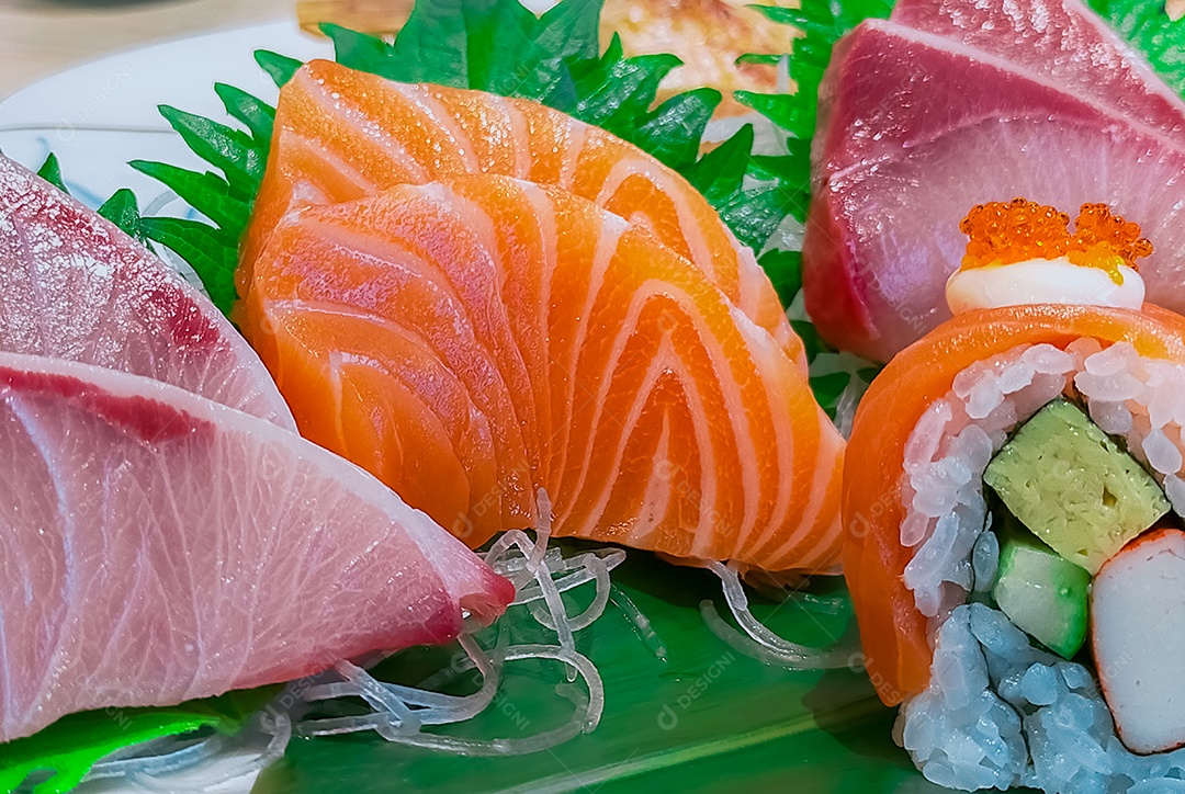 Comida japonesa servida em prato branco. Sushi e sashim de salmão
