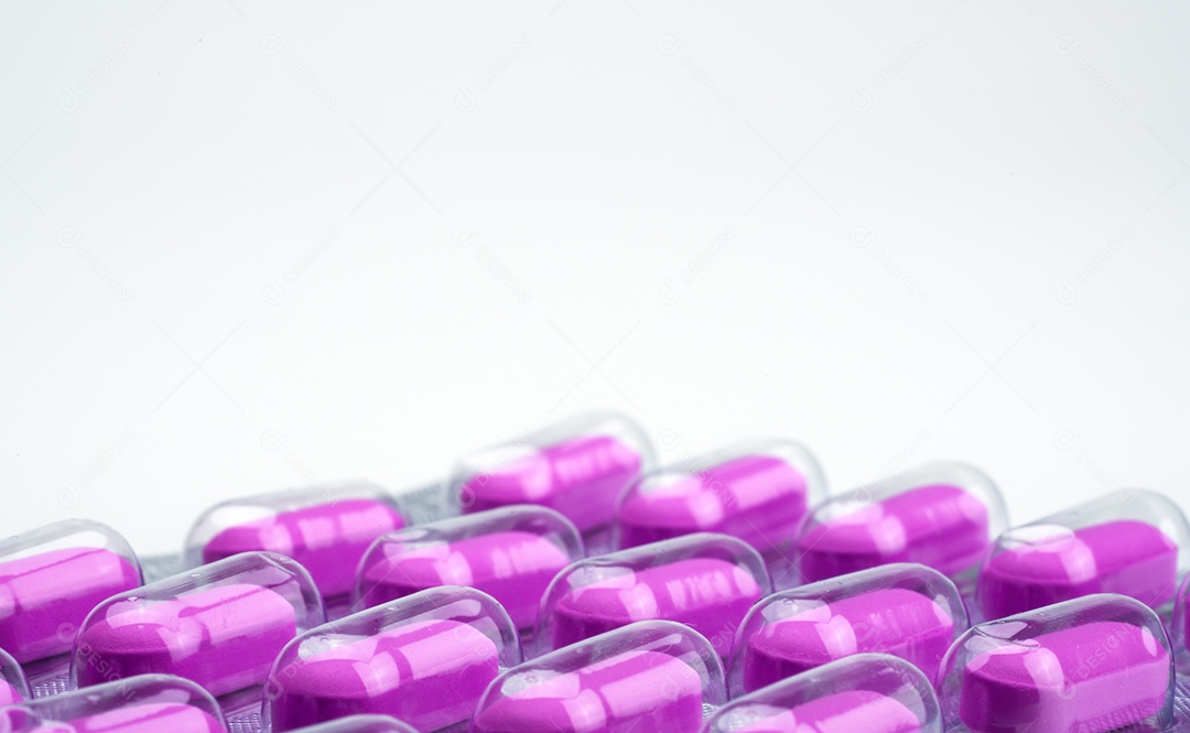 Tiro macro de pílulas de cápsulas roxas em blister na parte traseira branca