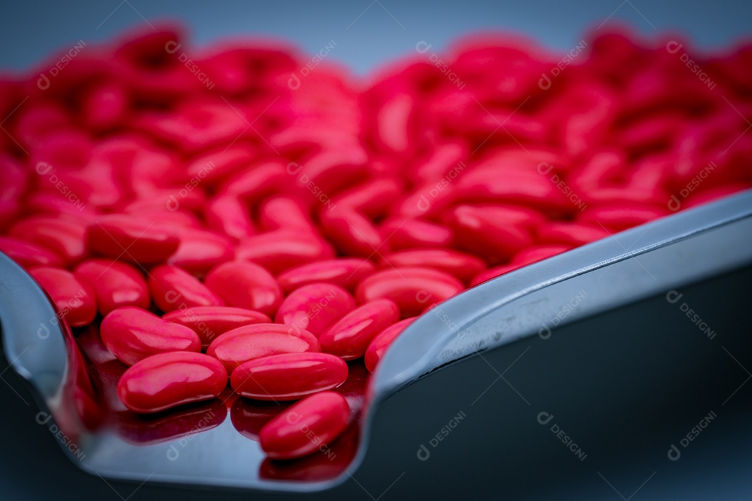 Detalhe de tiro macro de comprimidos revestidos de açúcar em forma de rim vermelho