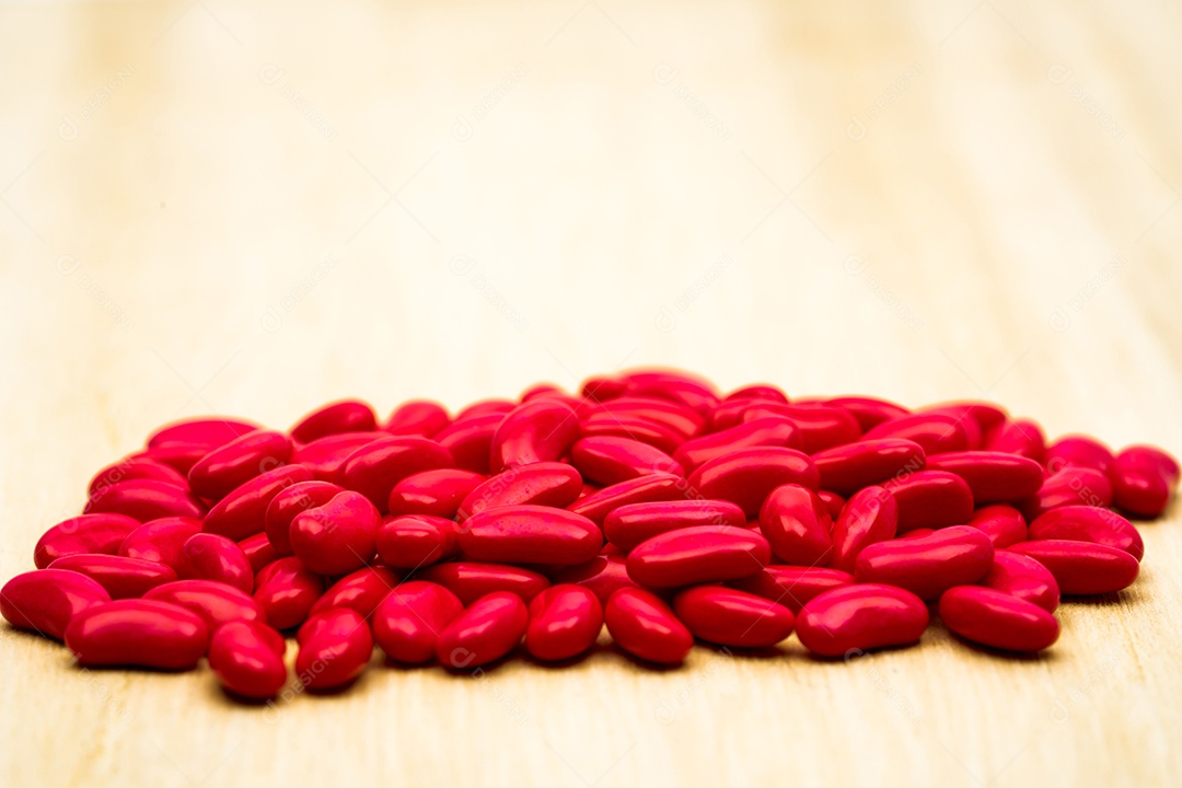 Comprimidos revestidos de açúcar de rim vermelho na mesa de madeira