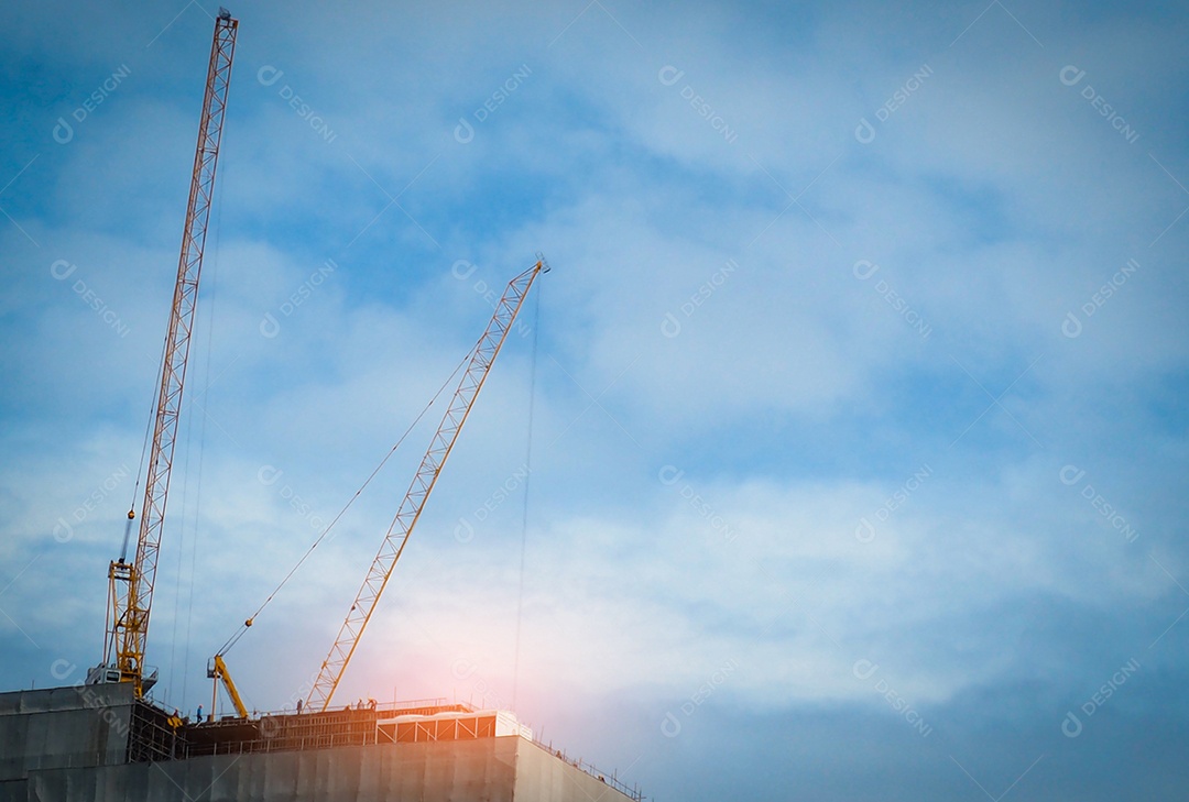 Guindaste de construção em prédio alto com céu azul e branco