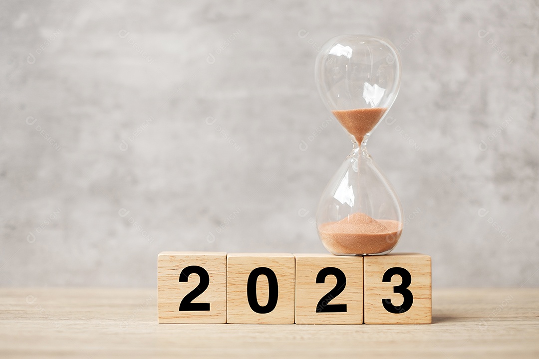 Texto de 2023 com ampulheta na mesa. Resolução, tempo, plano, objetivo, motivação, reinicialização, contagem regressiva e conceitos de feriado de ano novo