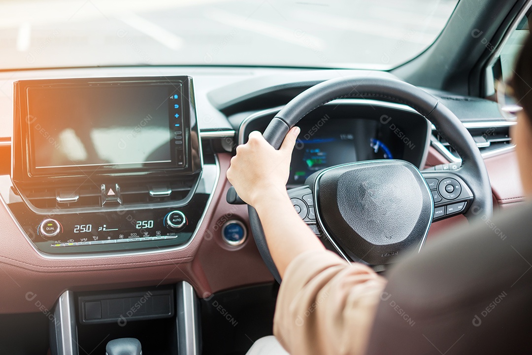 woman driver driving a car on the road, hand controlling the direction