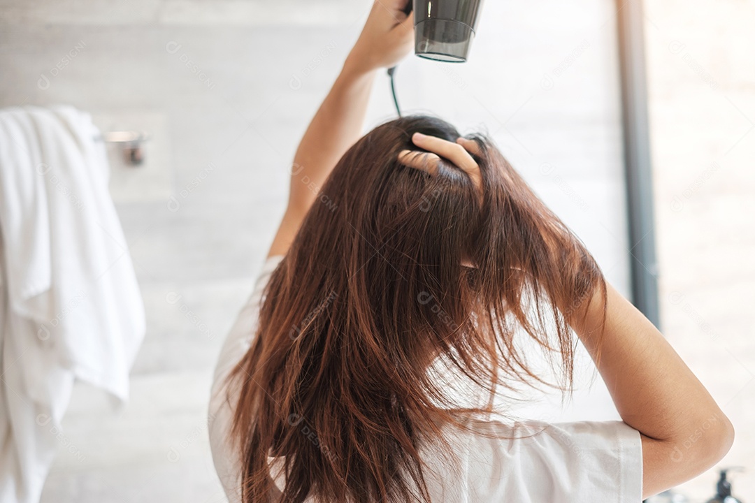 jovem usando secador de cabelo em casa ou hotel. Penteados