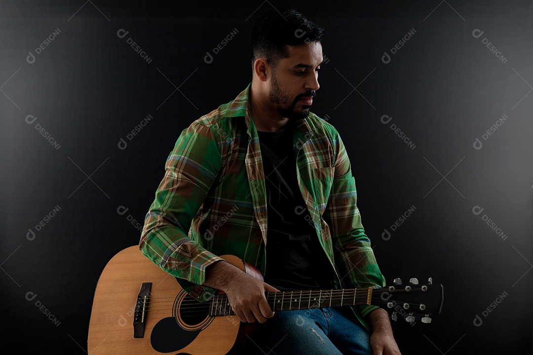 Homem jovem segurando instrumento violão sobre fundo isolado