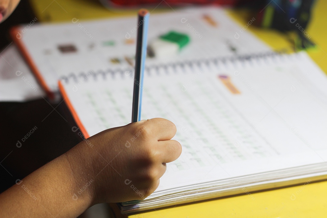 Pessoa estudante segurando lápis caderno