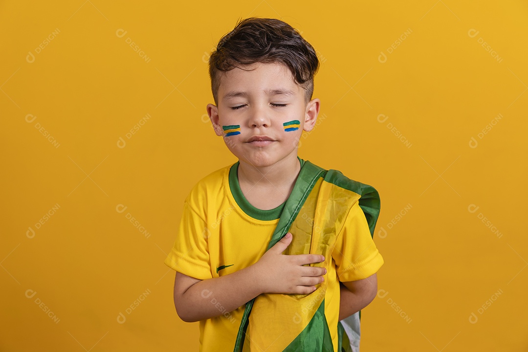 Menino jovem criança brasileiro torcedor do brasil sobre fundo amarelo