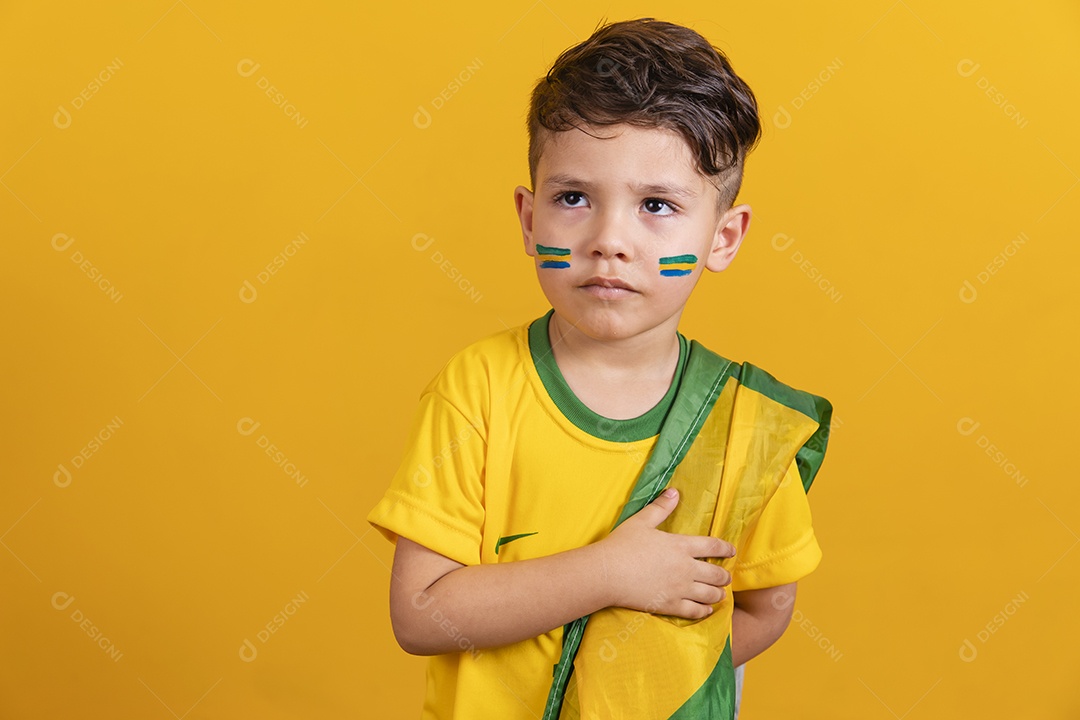 Menino jovem criança brasileiro torcedor do brasil sobre fundo amarelo