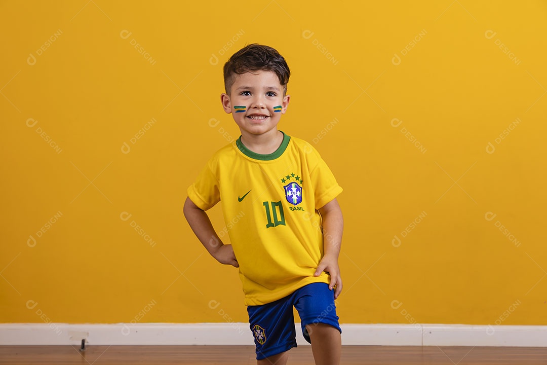 Menino jovem criança brasileiro torcedor do brasil sobre fundo amarelo