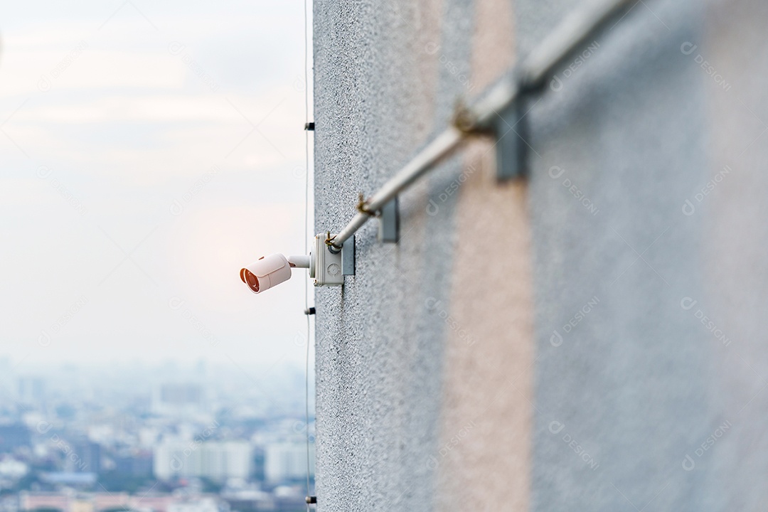 Câmera de CCTV moderna contra o fundo da cidade e do céu. vigilância
