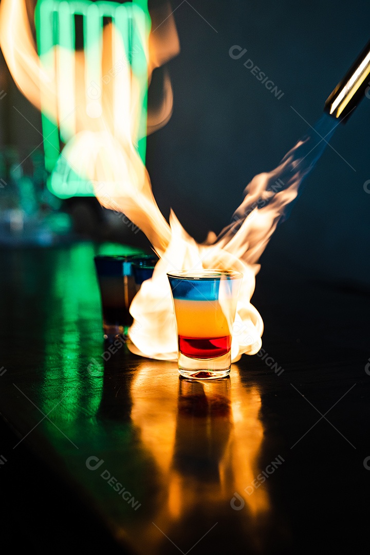 Coquetel colorido com chamas de fogo