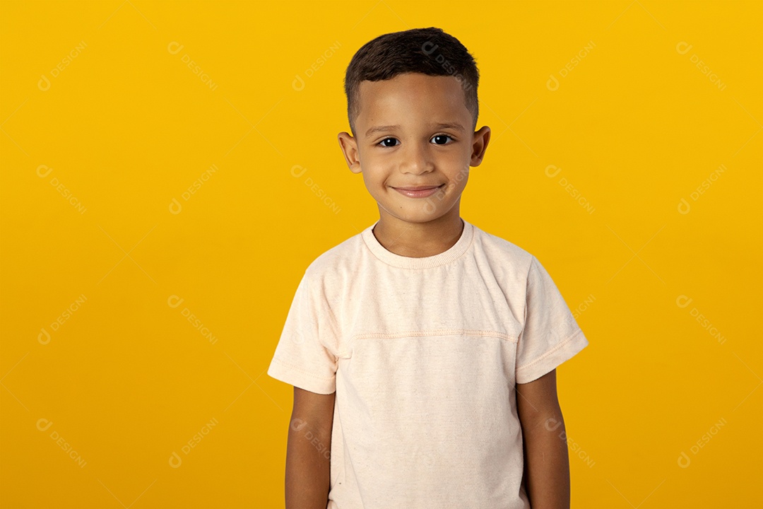 Menino de camisa clara feliz olhando para câmera Isolado sobre fundo amarelo