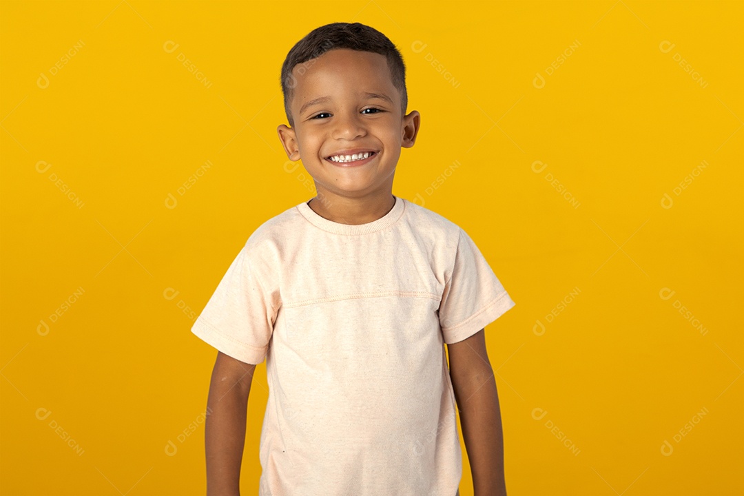 Menino de camisa clara sorrindo isolado sobre fundo amarelo