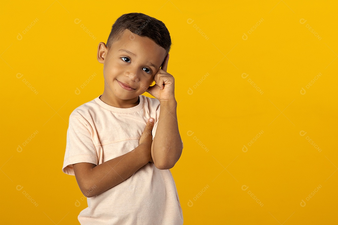 Menino de camisa clara pensando e com mão na cabeça pensativo isolado sobre fundo amarelo