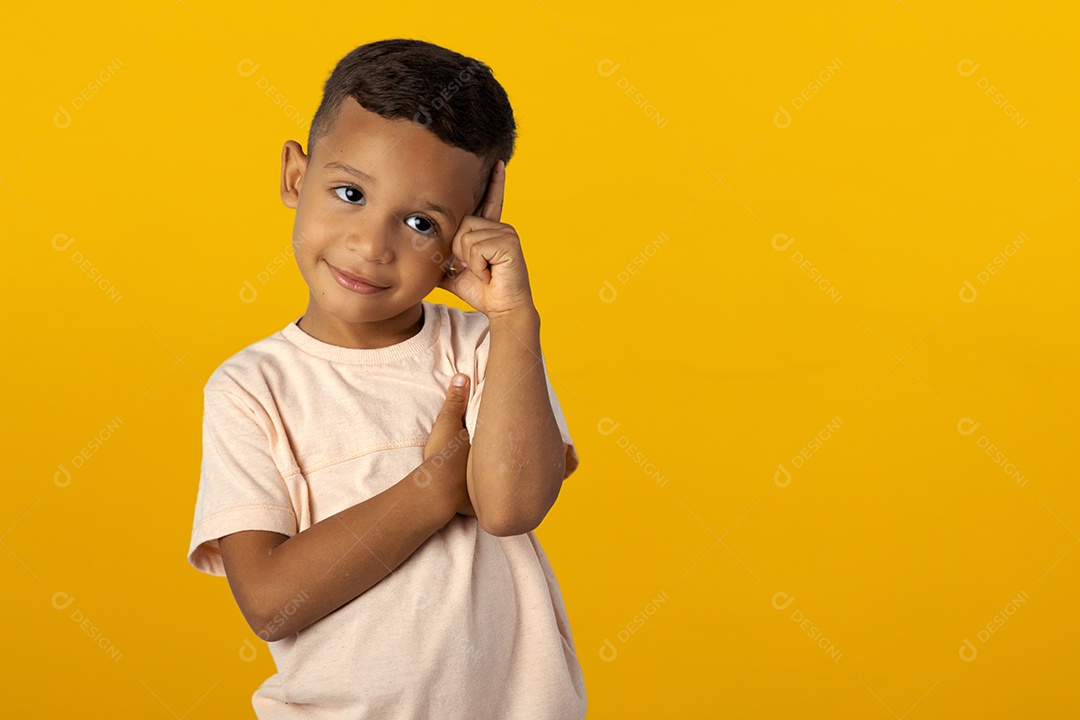 Menino de camisa clara pensando e com mão na cabeça pensativo isolado sobre fundo amarelo