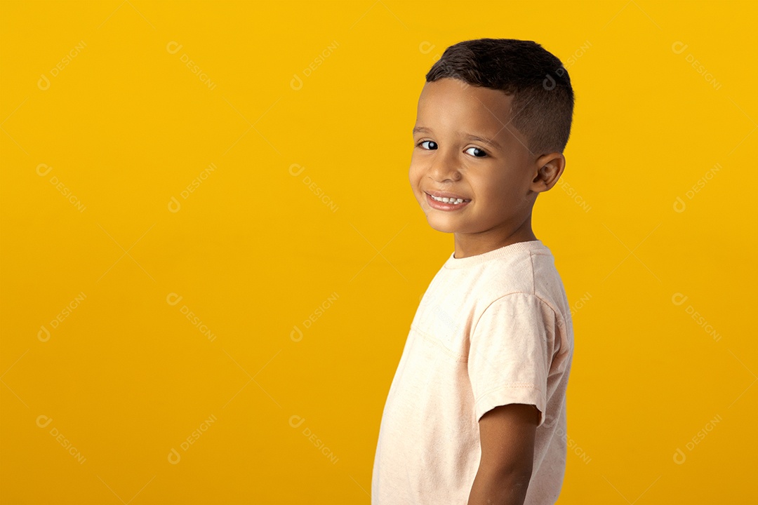 Menino sorridente de camiseta cinza isolado sobre fundo amarelo