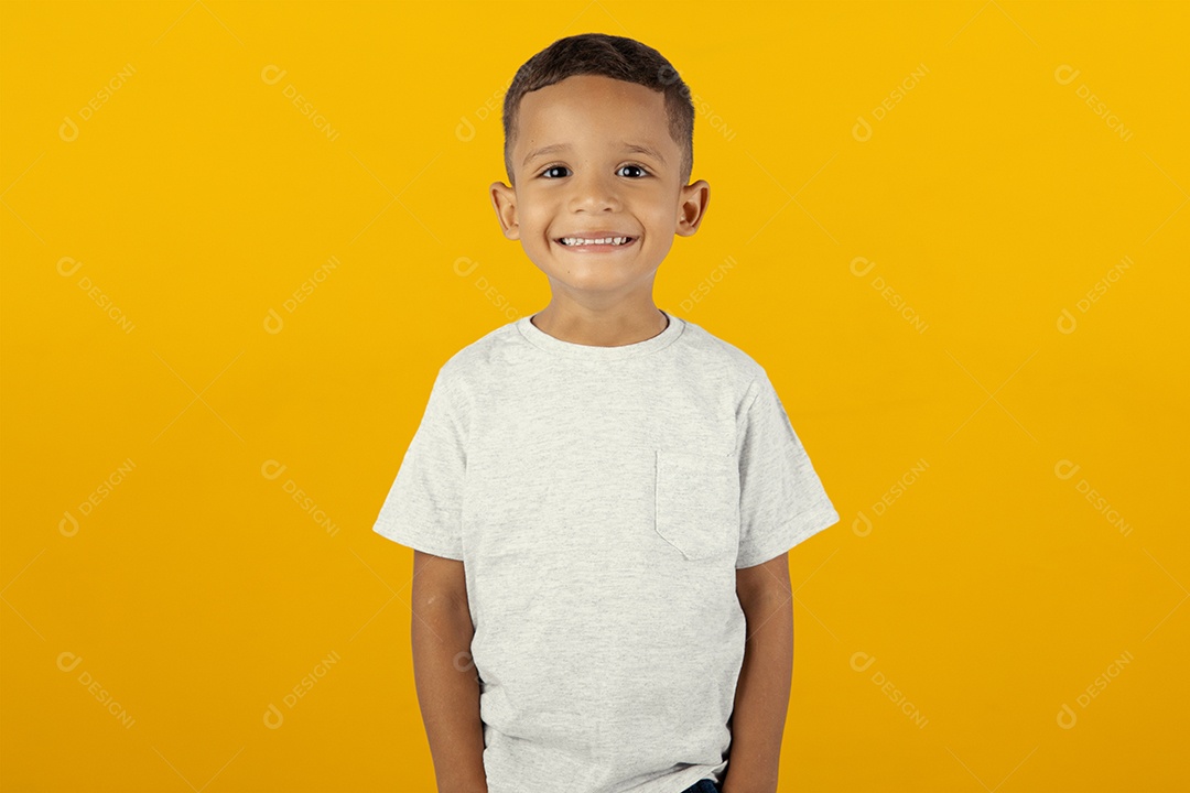 Menino feliz e sorridente olhando para câmera isolado sobre fundo amarelo