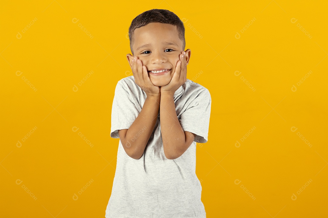 Menino feliz e sorridente tocando as maçãs do rosto com as mãos
