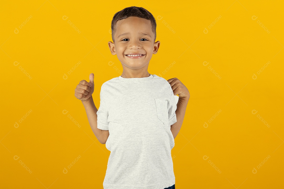 Menino feliz e sorridente com polegar para cima sobre fundo amarelo