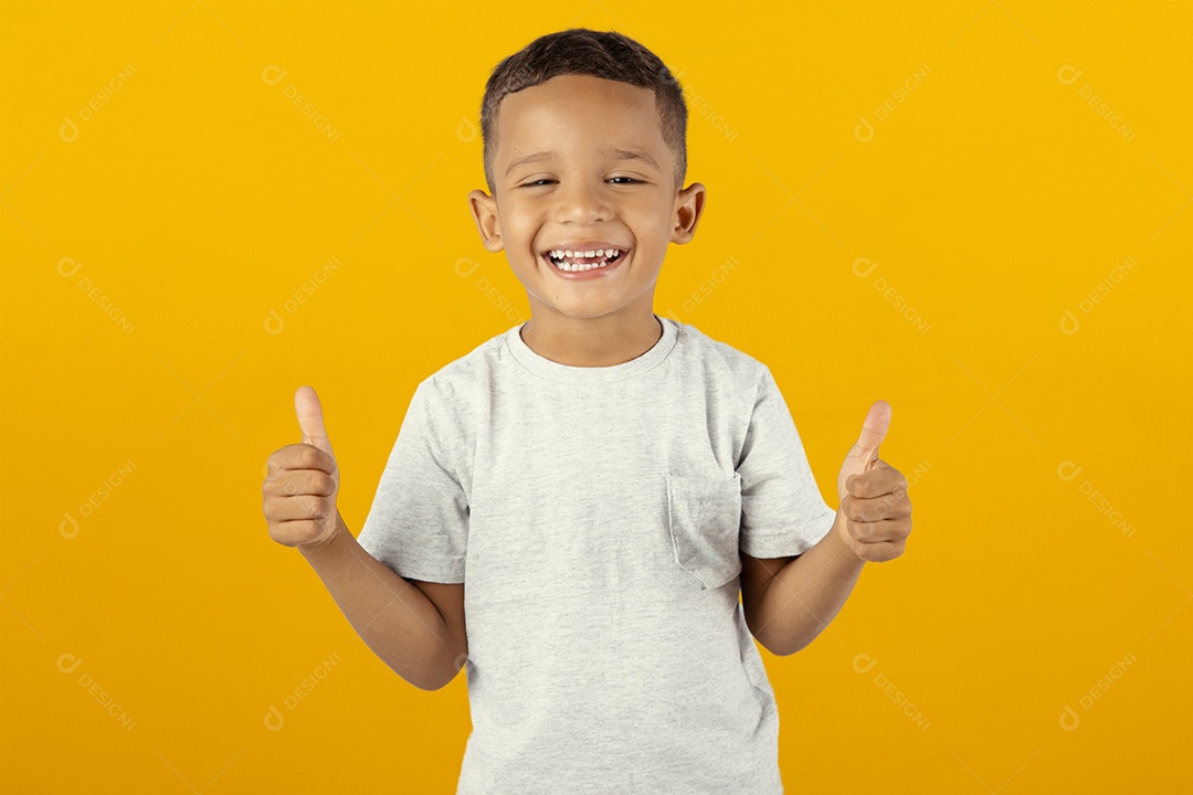 Jovem menino feliz e sorridente com os polegares para cima isolado sobre fundo amarelo