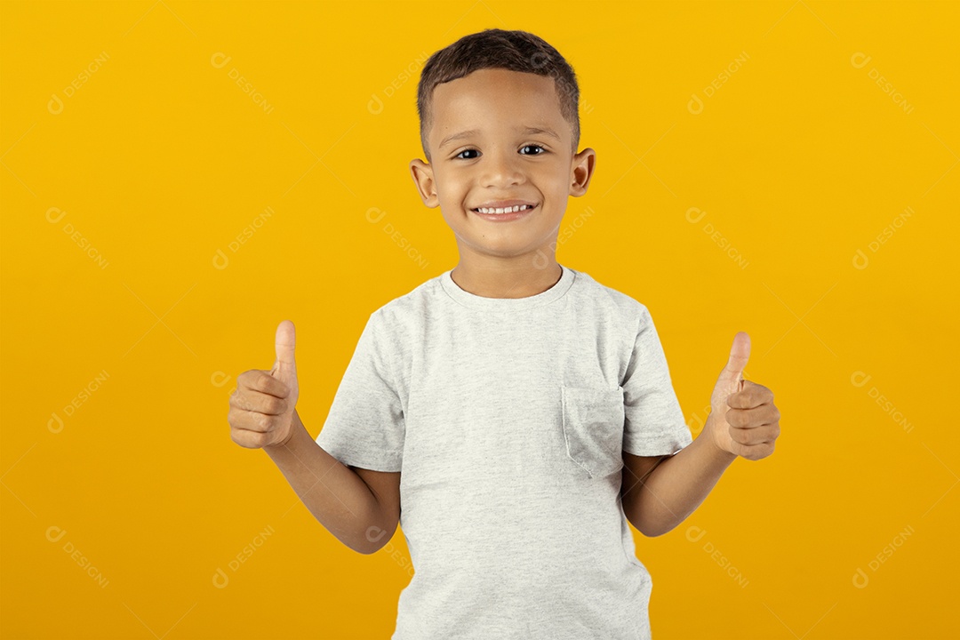Menino feliz sobre fundo amarelo com os polegares para cima
