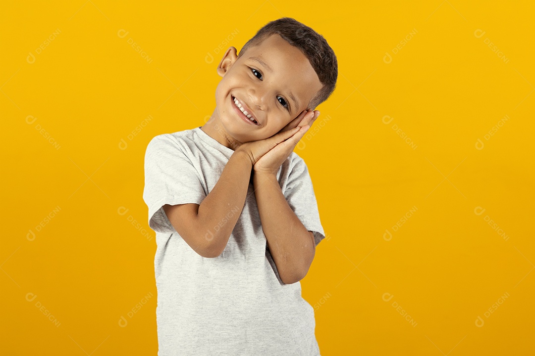 Menino feliz e alegre e sorridente isolado sobre fundo amarelo